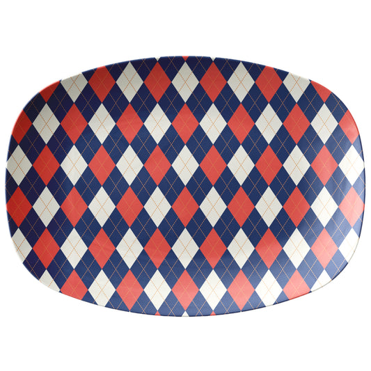 Oval serving platter with a diamond argyle pattern in navy, red and cream.