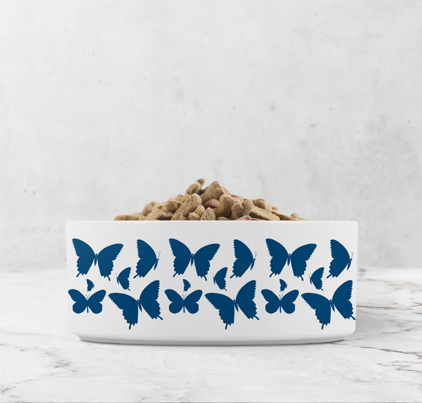 Hand drawn indigo blue butterflies are printed on a white ceramic dog or cat bowl.