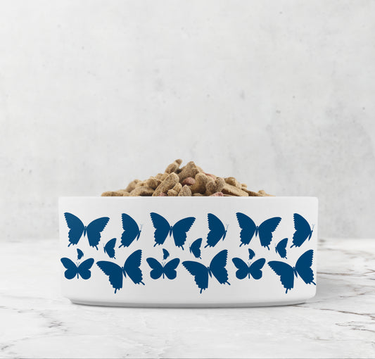 Hand drawn indigo blue butterflies are printed on a white ceramic dog or cat  bowl.