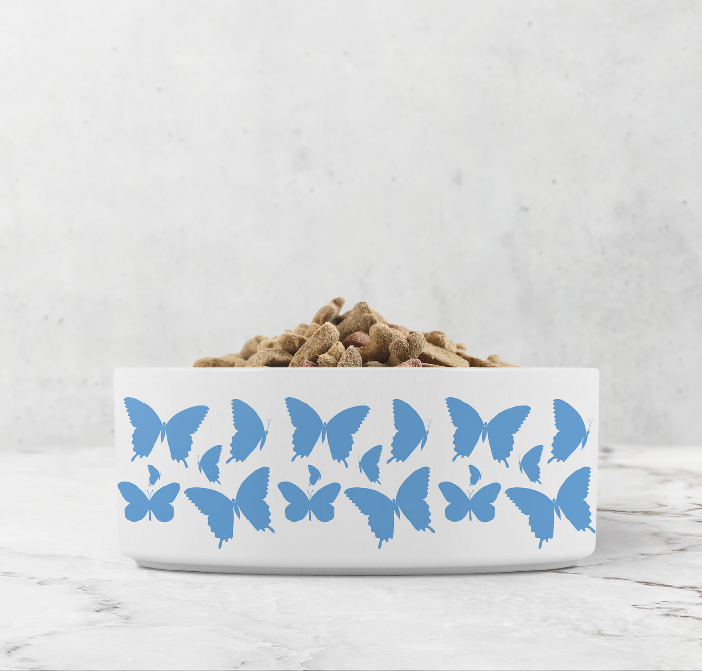 Hand drawn dancing butterflies in sky blue are printed on a white ceramic dog bowl.