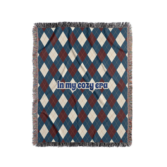 Argyle blanket that says In My Cozy Era, blue, red and cream.