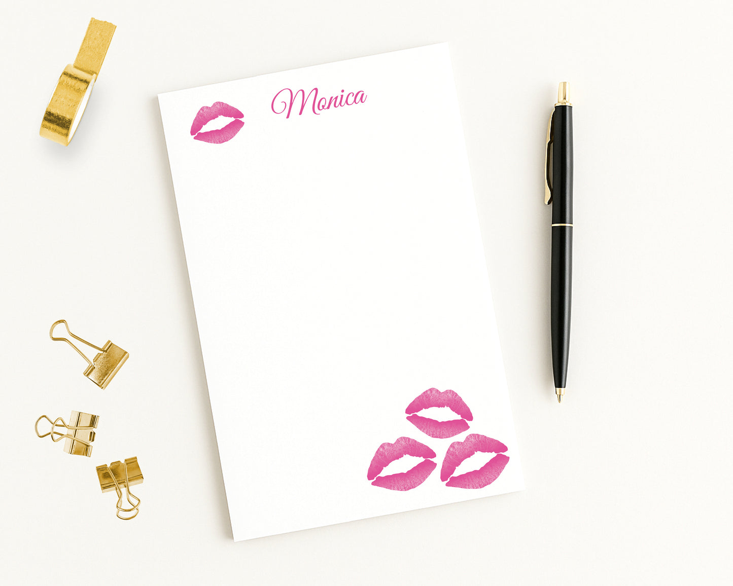 Personalized Notepad with hot pink lip prints and custom text, surrounded by gold clips and a pen on a white background.