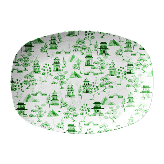 Green chinoiserie toile pattern featuring asian pagodas, bridges, mountains and trees printed on white serving platter.