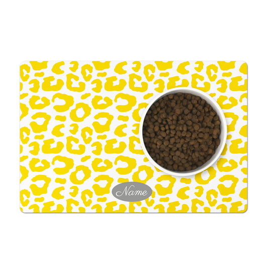Personalized pet bowl mat in a colorful yellow and white leopard pattern.