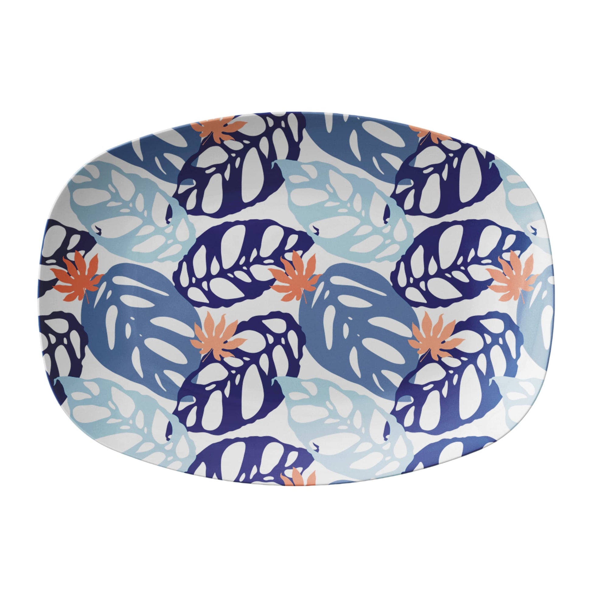 Pretty blue and white serving platter with a collage of monstera palm leaves with coral accents