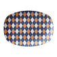Oval serving platter with an argyle diamond pattern in navy blue, orange and cream.