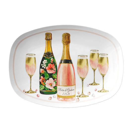 White oval serving platter featuring elegant champagne bottles, gold-accented champagne flutes, and shimmering loose gemstones scattered throughout, creating a beautiful touch of sparkle and sophistication. Customize the main champagne bottle label with names, a date, or your own special message.