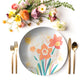 Floral narcissus plate with cutlery and flowers on a white background