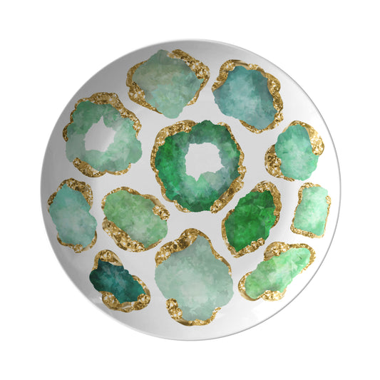Decorative dinner plate with green crystal gemstone patterns and gold accents on a white background