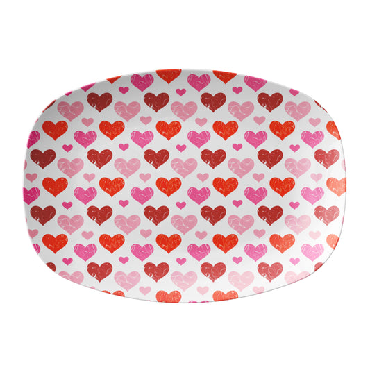 Oval-shaped serving platter with a pattern of red and pink hearts on a white background