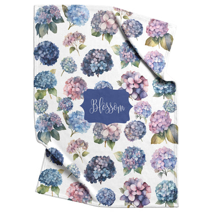 Pet blanket with purple, pink and blue hydrangeas floral pattern on a white background. Personalized with any custom text at center.