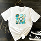 Women's graphic print tee aqua blue and gold. White crewneck short sleeve tshirt with aquamarine birthstone gems with gold accents