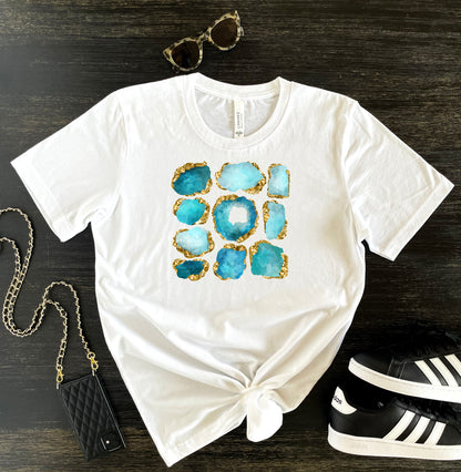 Women's graphic print tee aqua blue and gold. White crewneck short sleeve tshirt with aquamarine birthstone gems with gold accents