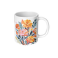 White ceramic mug with colorful marigold floral design on a white background