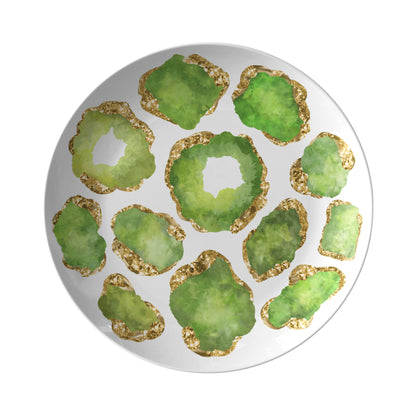 Round white plate with green and gold decorative crystal gemstone elements printed on a white background