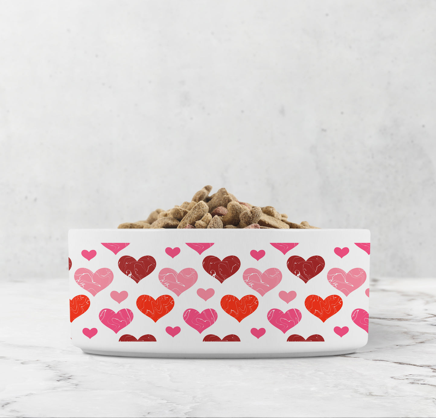 White pet bowl has red and pink hearts printed all over it