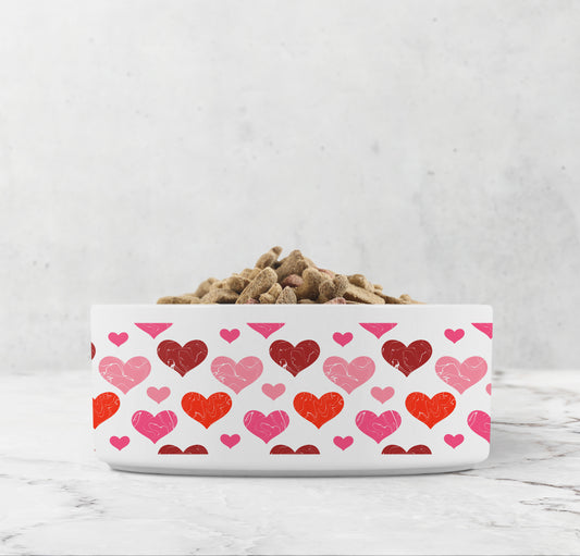 White pet bowl has red and pink hearts printed all over it
