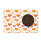 Orange and pink hearts are printed all over a white pet placemat.