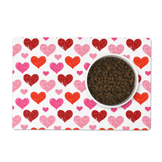 White pet placemat has red and pink hearts pattern printed all over.