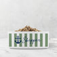 White ceramic pet bowl with sage green nautical stripes, navy blue anchor design and custom pet name on marble surface