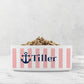 Dog or cat food bowl with pink stripes, Navy Blue anchor and custom pet name on a marble surface.