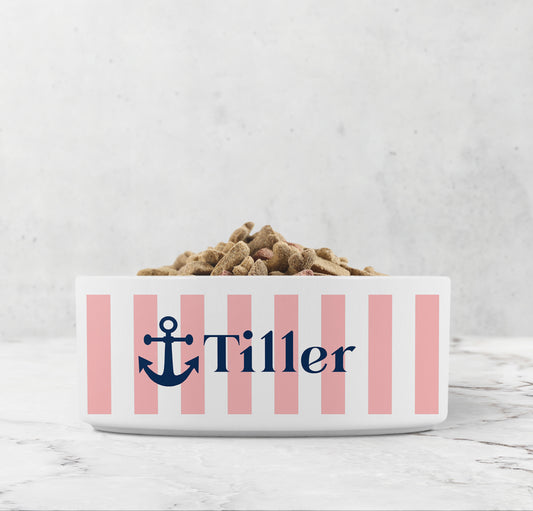 Dog or cat food bowl with pink stripes, Navy Blue anchor and custom pet name on a marble surface.