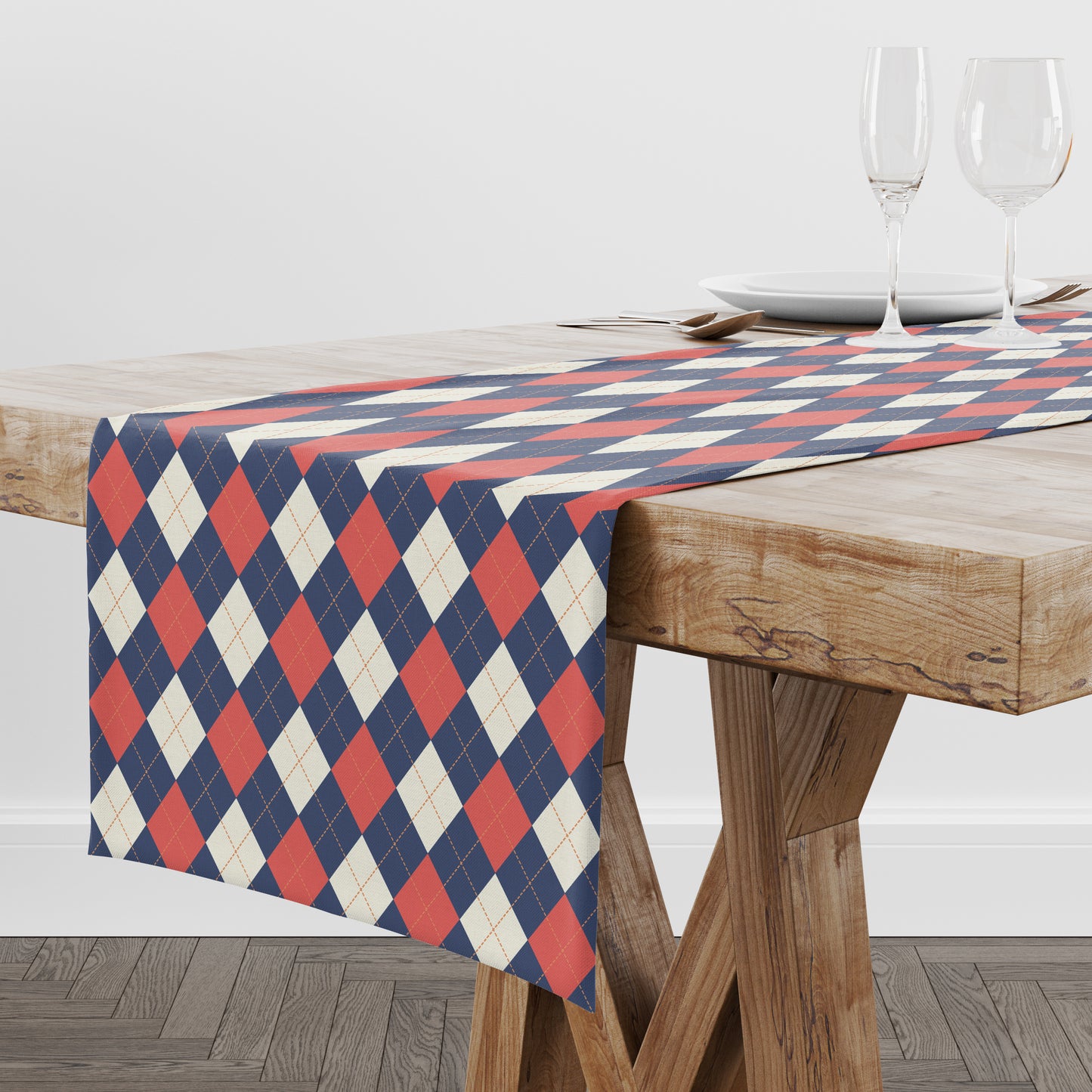 Arygle diamond patterned table runner in navy, red and cream. Shown on a wood table.