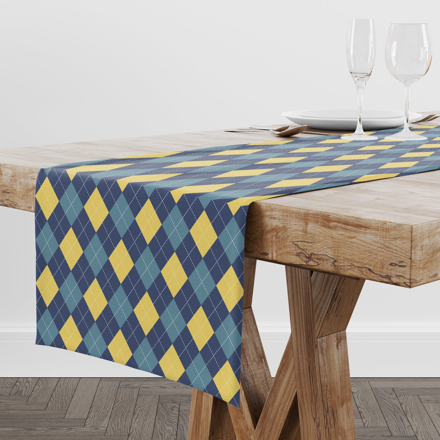 Table runner with blue and yellow geometric diamond argyle pattern on a wooden table.