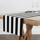 Black and white stripe table runner shown on a wood table.