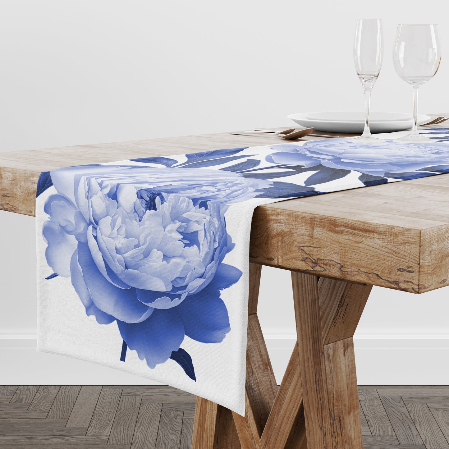 Bold blue peony flower print on white table runner linen draped on a wooden dining table