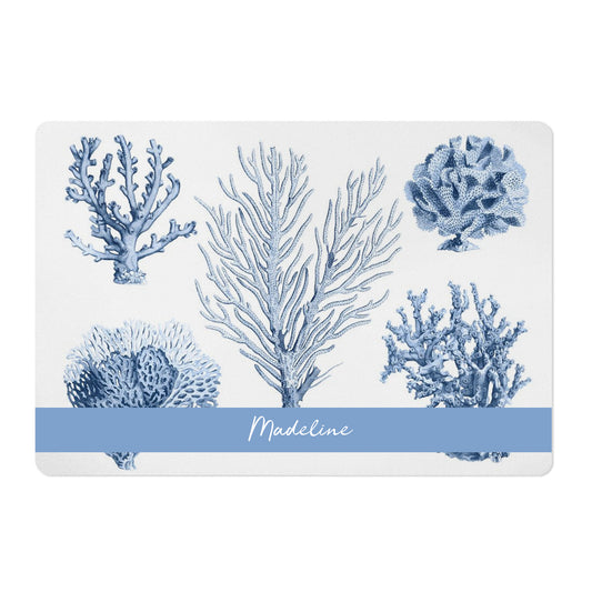 Pet bowl spill mat has gorgeous blue coral sea life printed on white pet placemat.
