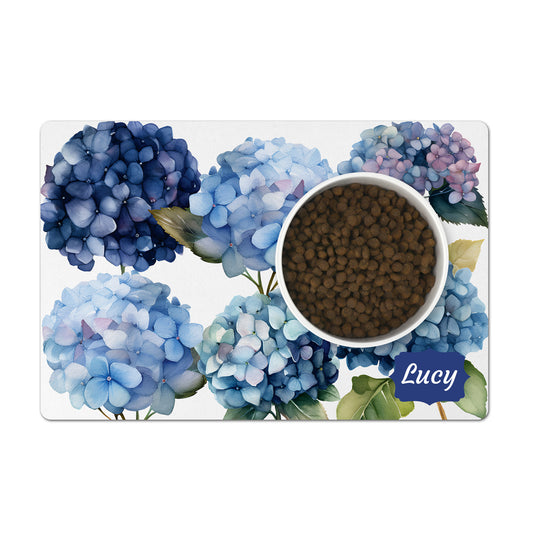 Blue hydrangea flowers are printed on a white dog feeding mat personalized with any text.
