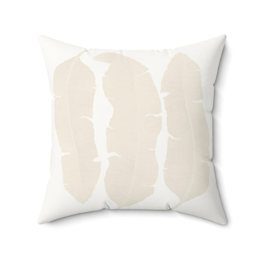 White square throw pillow with cream banana leaves print.