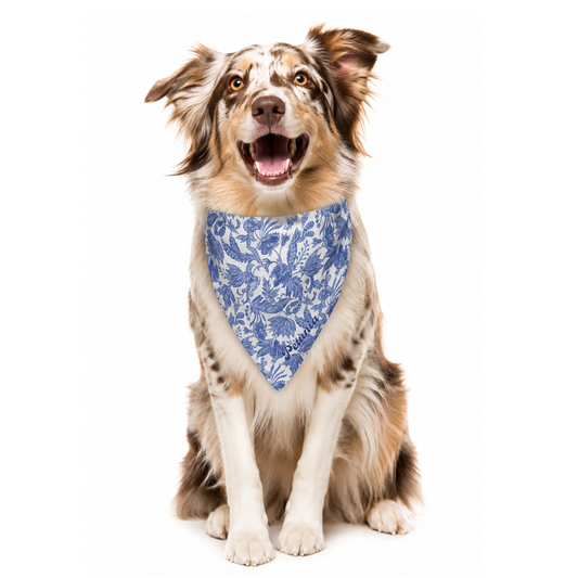 Dog wearing a blue floral bandana with custom name on a white background