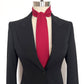 Black suit jacket with a red necktie cravat on a mannequin against a white background