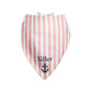 Pink and white striped custom dog bandana with pet's name and an anchor on a white background