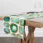 Table runner with green and gold agate design on a wooden table