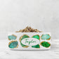 Beautiful emerald green and gold jewels are printed on a white ceramic bowl. Personalize with any name or word for your dog or cat.