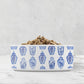 White ceramic dog bowl has a pattern of chinoiserie ginger jars in blue and white printed all around the perimeter.
