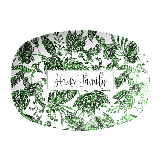 Green floral batik pattern is printed on a white oval serving platter personalized with any name or text.