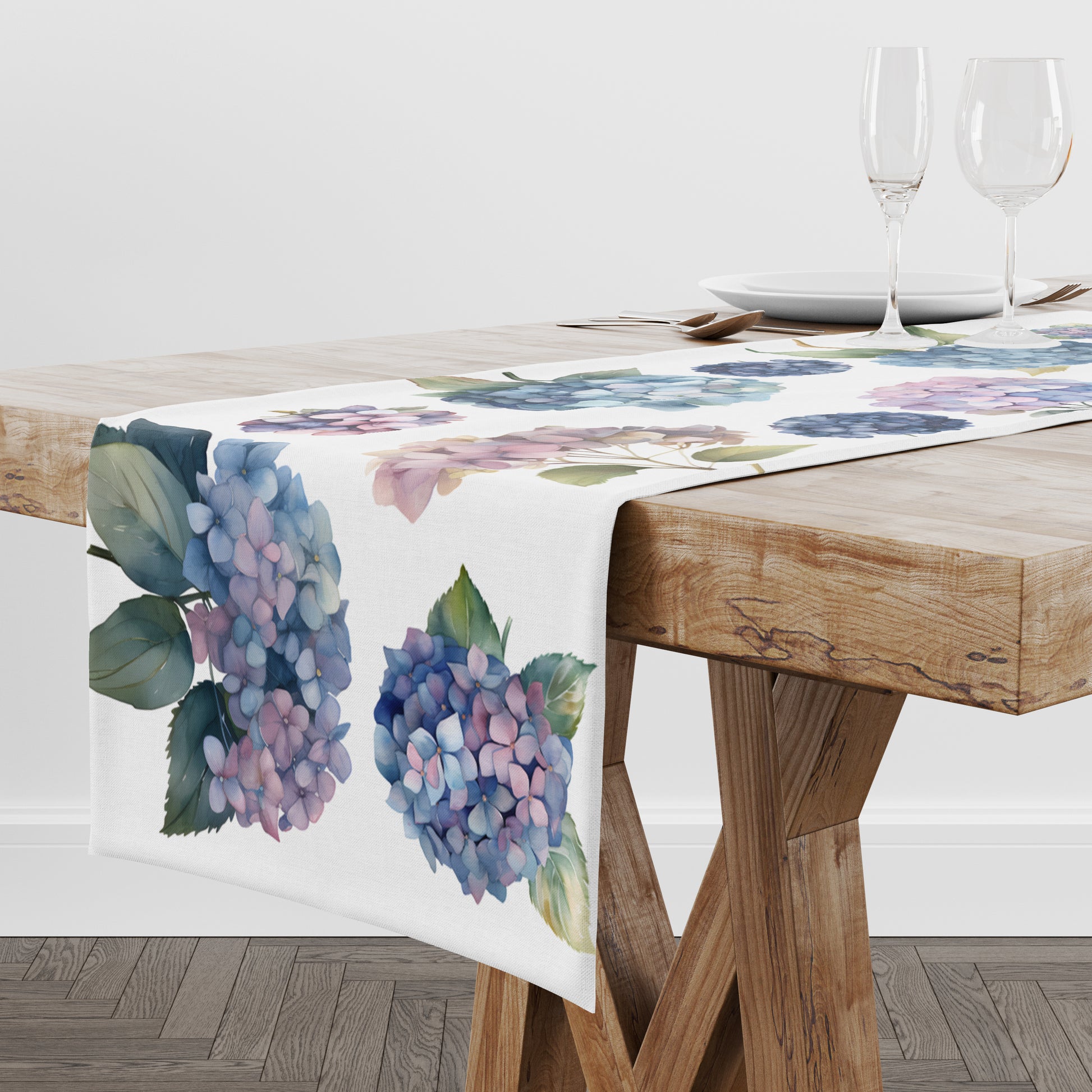 Floral table runner featuring hydrangea flowers in blue, pink and purple on a wooden table.