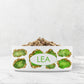 Personalized pet bowl has peridot green and gold jewels printed on a white ceramic dish. Add any name or word to customize.