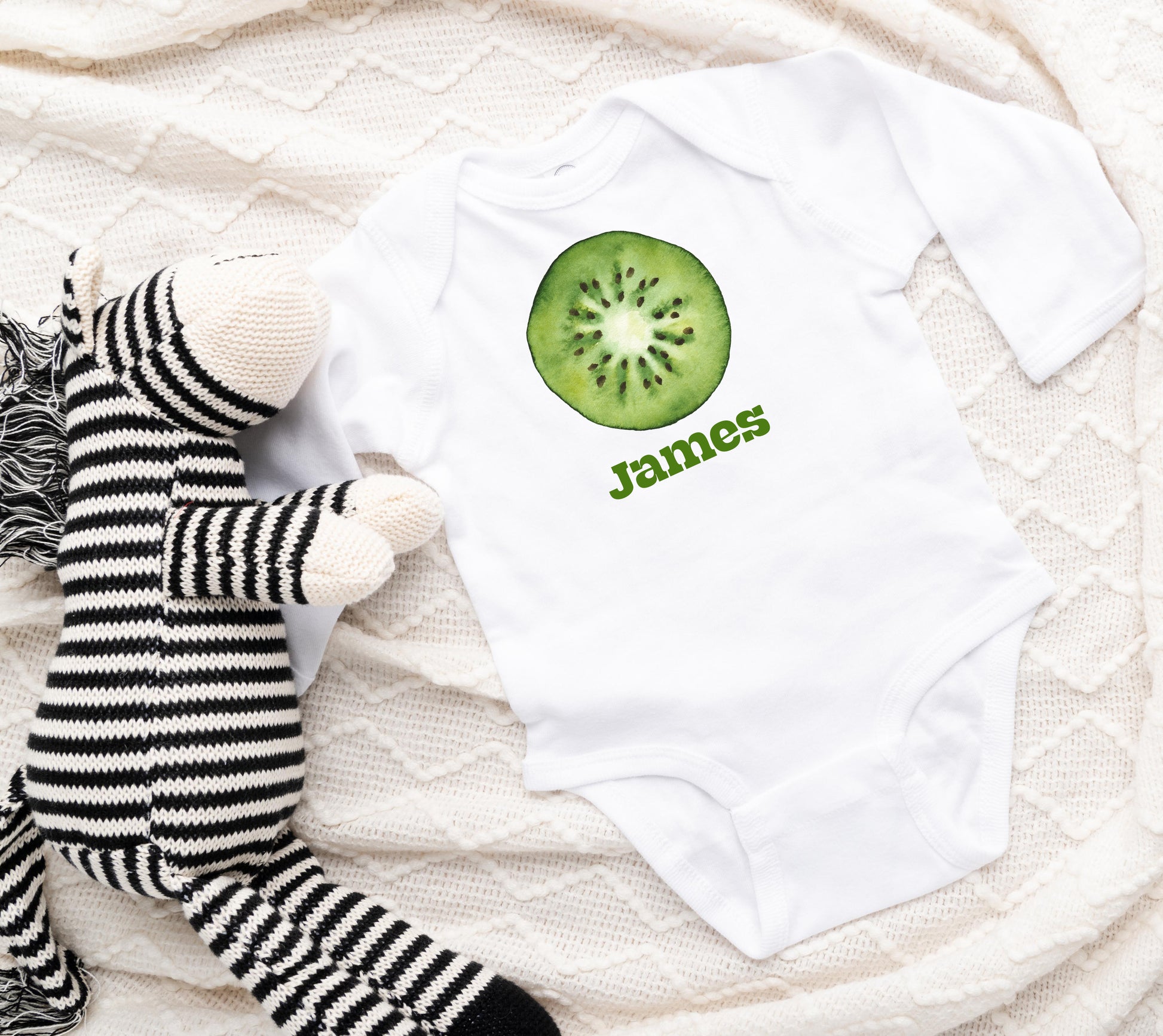 White baby onesie with a printed kiwi graphic and personalized custom text of your choice.