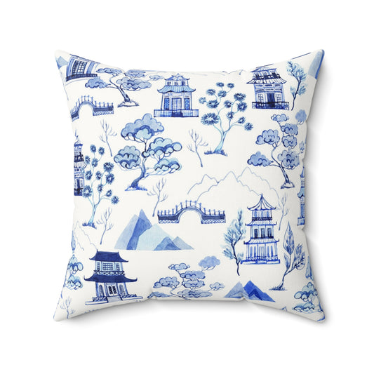 Decorative pillow with blue and white chinoiserie landscape and pagodas pattern on a white background