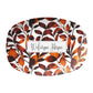 Customized serving platter has rust orange color leaves pattern and custom phrase at center.