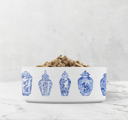 White ceramic dog bowl has blue ginger jars printed all around the outside diameter and is chinoiserie inspired.