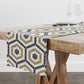 Mosaic tile table runner in black, gold and cream in a hexagon pattern on a wood dining table