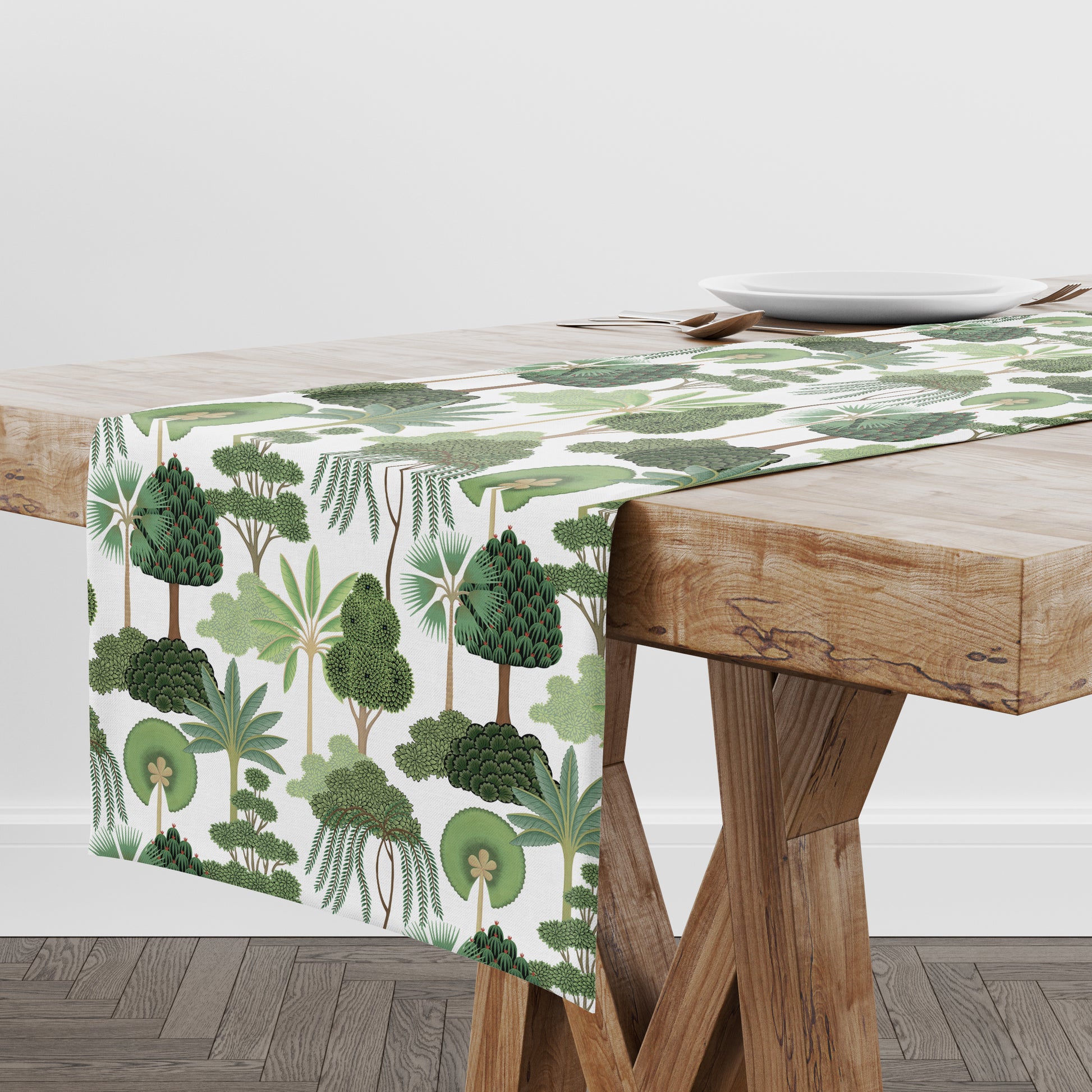 Tropical tree print table runner in green and white on wood farmhouse style dining table.