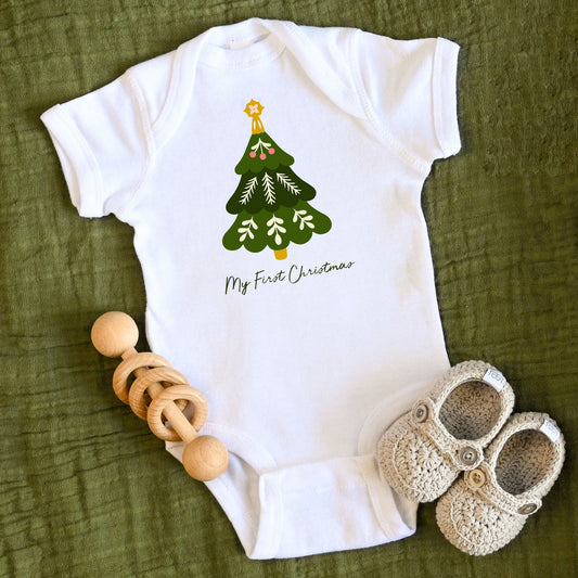 A cute Christmas tree and the words My First Christmas are printed on this white one piece bodysuit for babies.
