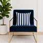 Navy blue armchair with a navy blue and white striped pillow in a room with a plant.